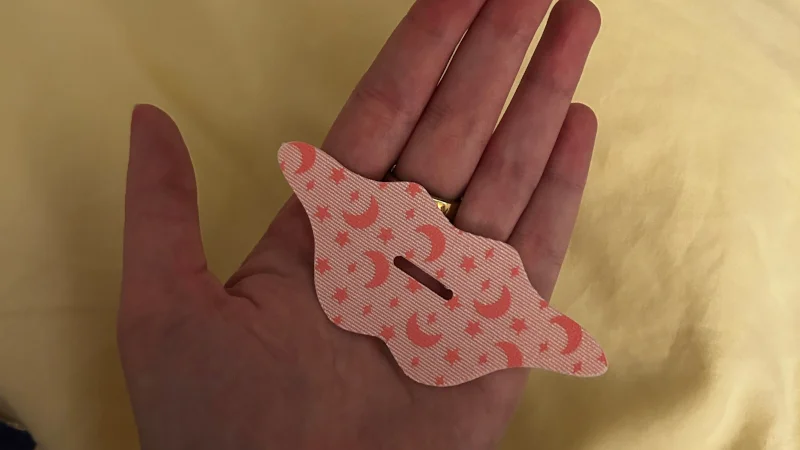 A person holding a mouth tape patch