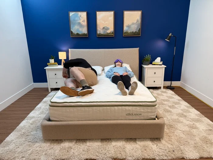 Two testers lay side by side on the Silk & Snow Organic mattress to test motion isolation
