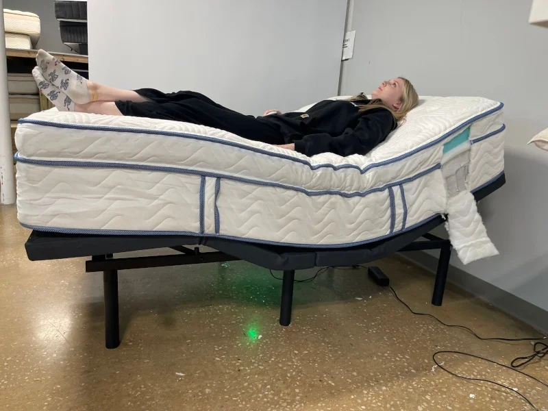 Riley Otis tries a DLX Premier Hybrid mattress on an adjustable base.