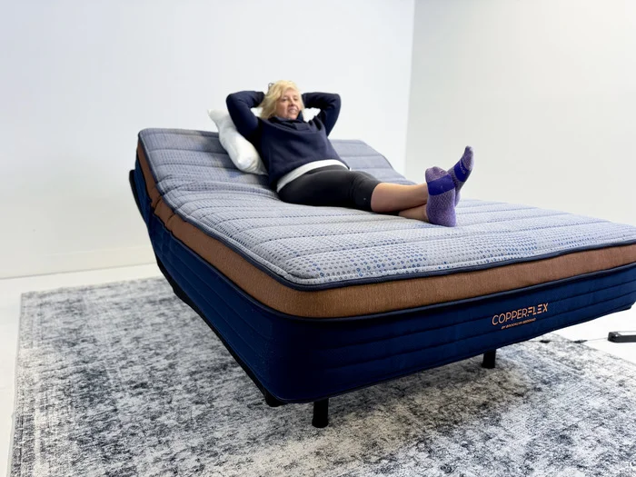 A woman enjoying the adjustability of the Brooklyn Bedding CopperFlex Mattress.