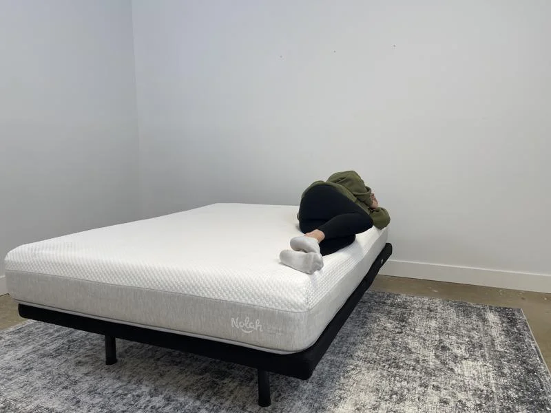 Our tester side-sleeping on the Nolah Original AF Mattress