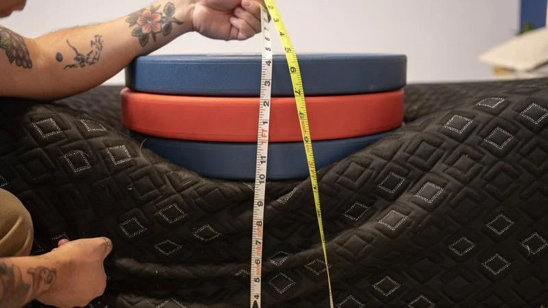 Our tester measures the sinkage from weight plates along the edge of the Beautyrest Black Hybrid XCS Mattress