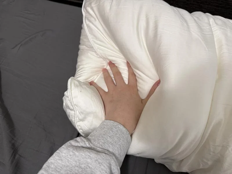 Our tester pressing their hand firmly into a Cozy Earth Silk Pillow