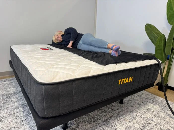A woman lays on a pressure mat on the Titan Plus mattress