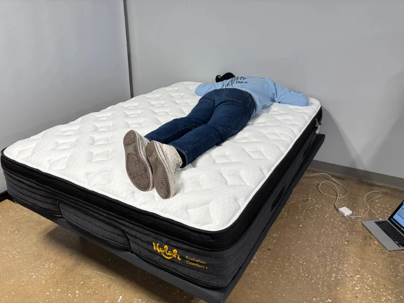 A mattress tester stomach sleeping on the Nolah Evolution Comfort Plus.