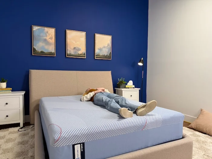 A woman lying on her back on the Sealy Posturepedic mattress.