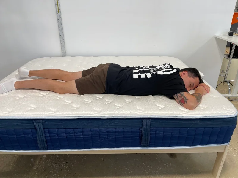 Our tester stomach-sleeping on a Glacier Summit Hybrid Mattress