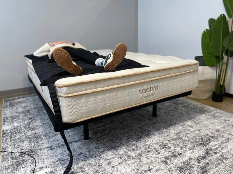 A person back-sleeping on a Saatva Latex Hybrid mattress.