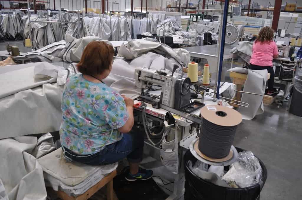 workers sew mattress cover together