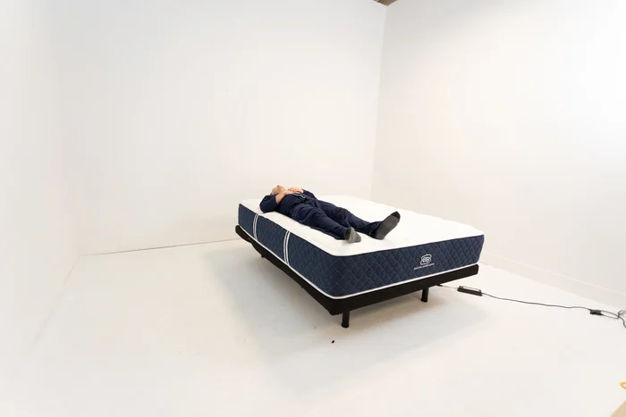 A man lying on his back on the Brooklyn Bedding Signature Hybrid.