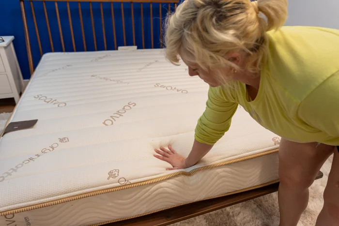 Our tester pushes down on the surface of the mattress