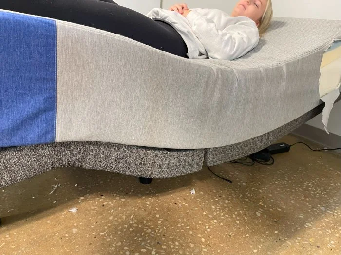 A woman lying on a Casper The One mattress that's resting on top of an adjustable base.