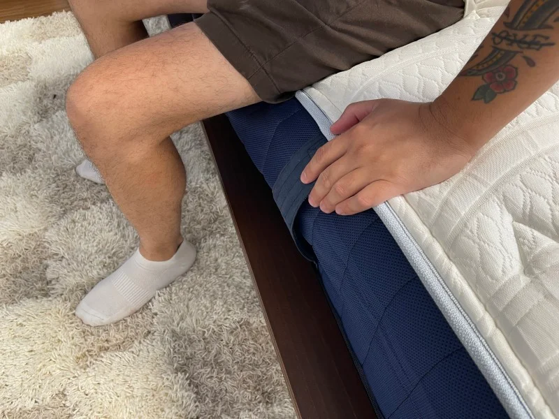 Our tester performs a seated edge support test on the Glacier Original Hybrid Mattress