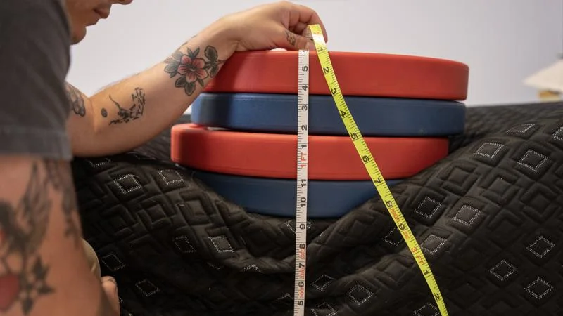 Our tester measures the sinkage from weight plates along the edge of the Beautyrest Black Hybrid XCS Mattress