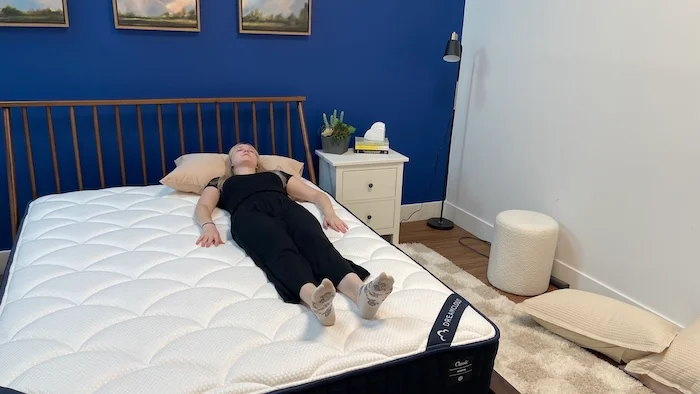 A woman sleeping on her back on the DreamCloud mattress.