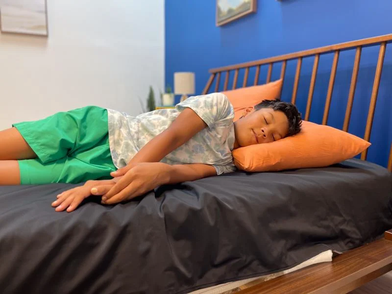 Our young tester side-sleeping on the Helix Kids 8-Inch Mattress
