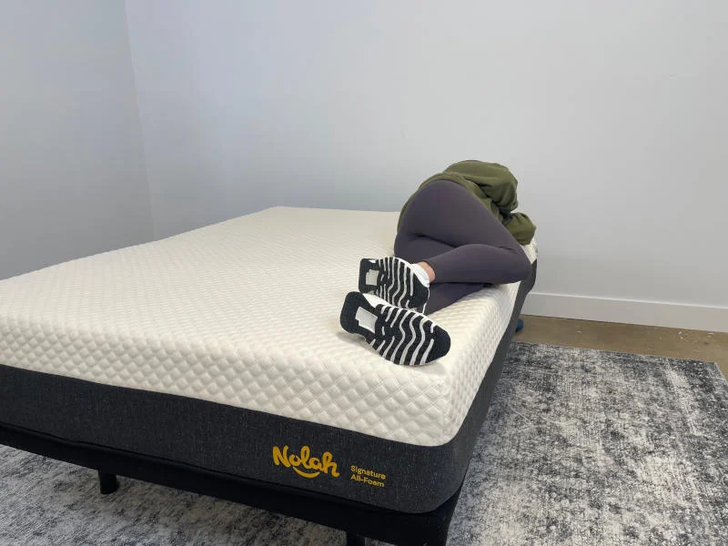 Our tester side-sleeping on the Nolah Signature Mattress