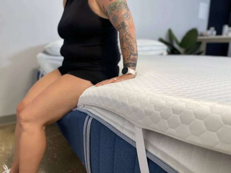 Our sleep expert Sosha Lewis checks out the edge support on a Helix Dual Comfort Mattress Topper