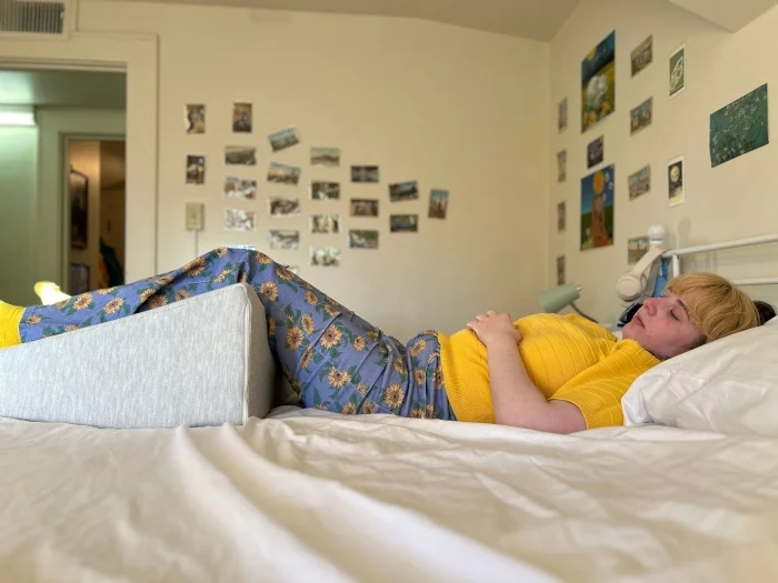 Our expert Livvi DiCicco, CSSC, lounges with a Helix Wedge Pillow.