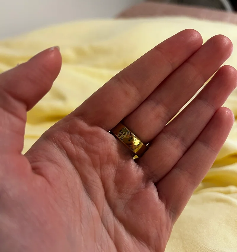 A palm-up shot of the RingConn ring on the middle finger of the left hand.