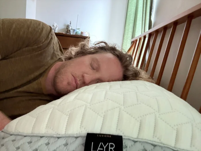 Our tester tries the Luxome LAYR pillow in a side-sleeping position.