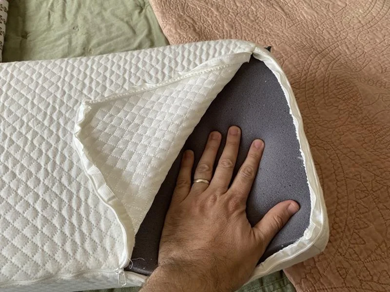 Our tester presses their hand into the foam inside a Side Cube pillow.