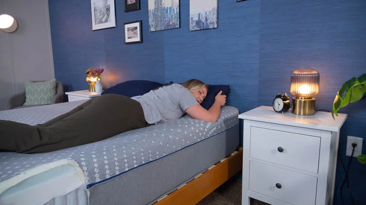 A woman lying on the Sealy Posturepedic in the stomach-sleeping position.