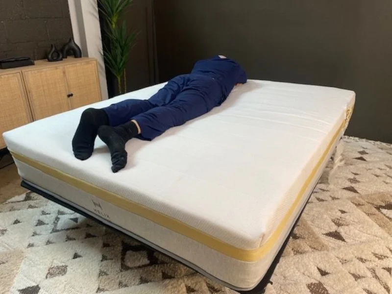 Our tester stomach sleeping on a Helix Dawn Mattress