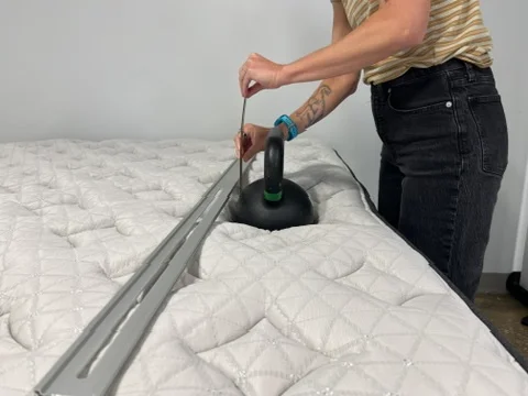 Our tester performs a sinkage test on a Helix Midnight Luxe Mattress
