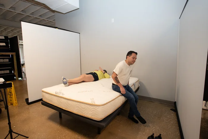 Two testers try out the Zenhaven mattress to test its motion isolation