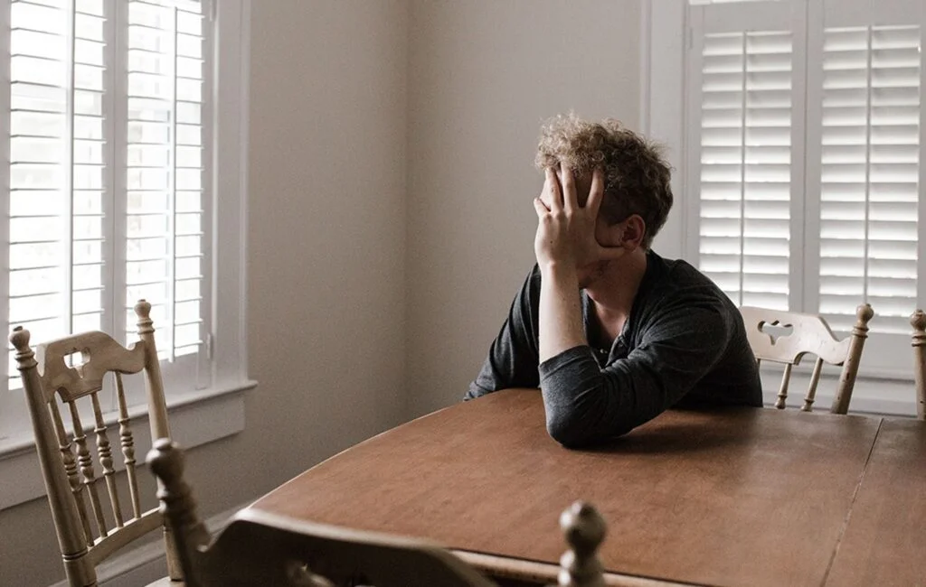 person frustrated at kitchen table