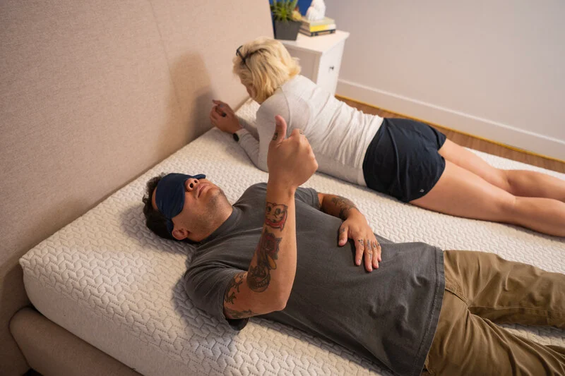 Two testers gauge the bed's motion isolation by seeing if one person can feel the other's movements