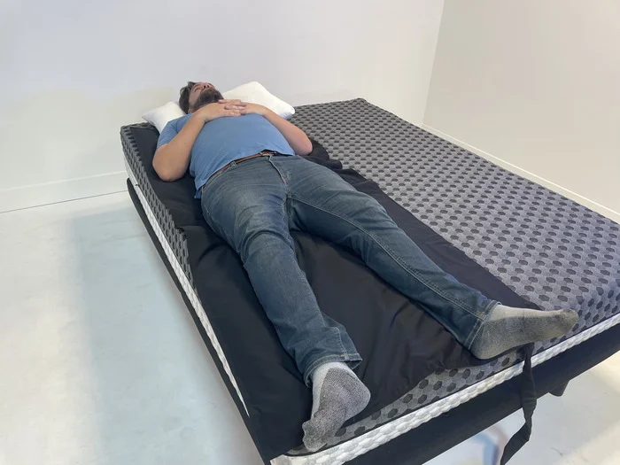 A man lying on his back on the firm side of the Layla mattress.