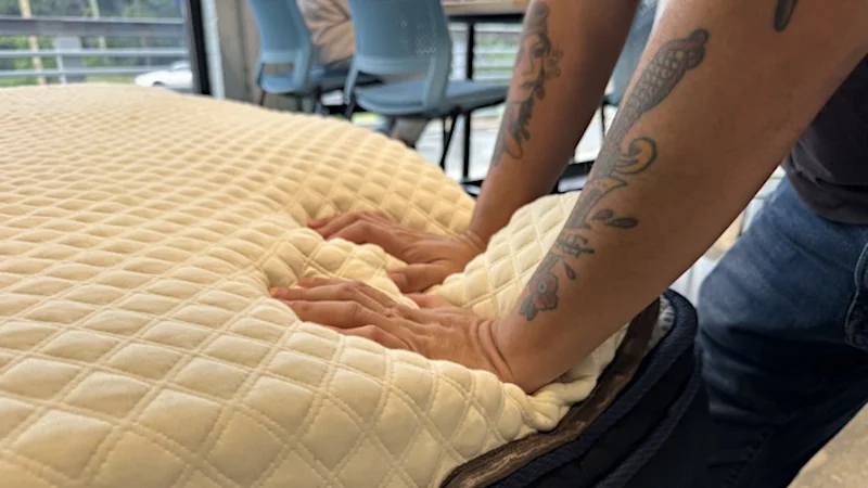 Our mattress tester pressing their hands deeply into a Nolah Mattress Topper