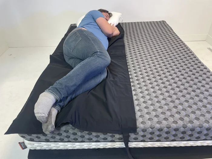 A man lying on his side on the firm side of the Layla mattress.