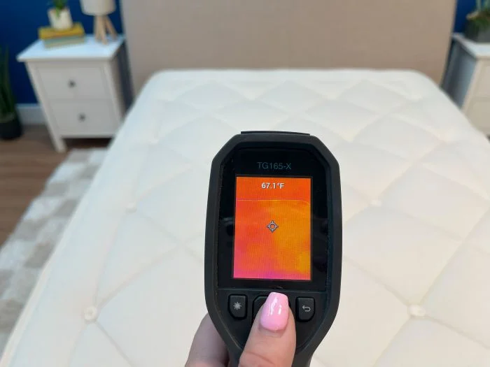 A closeup of a thermal gun reading the neutral temperature of the Avocado Luxury Organic mattress.