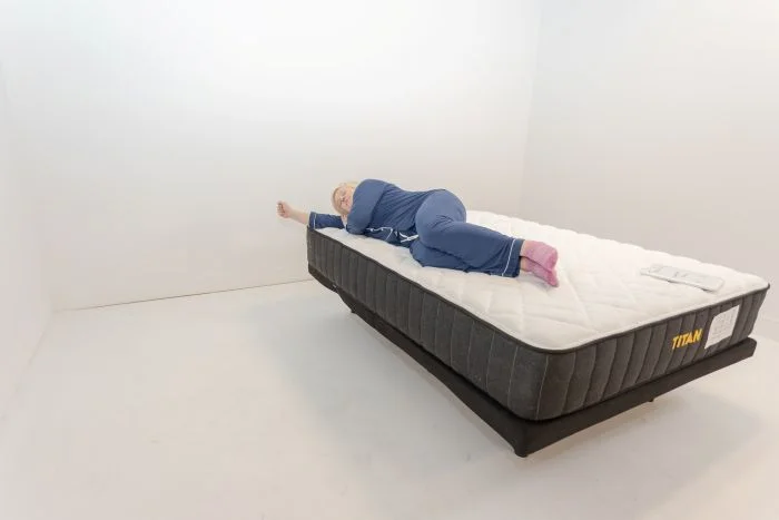 A woman lays on her side on the Titan Plus