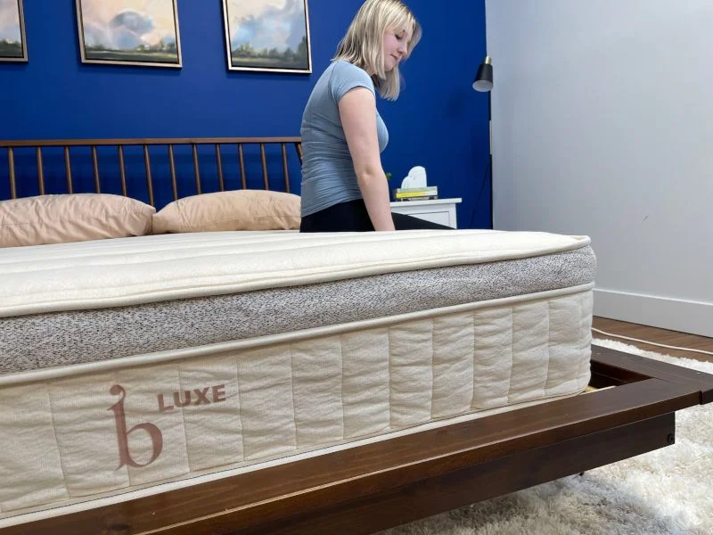 Our tester performing a seated edge support test on a Birch Luxe Natural Mattress