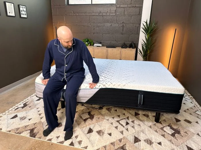 A man sits on the edge of the Nectar Premier mattress