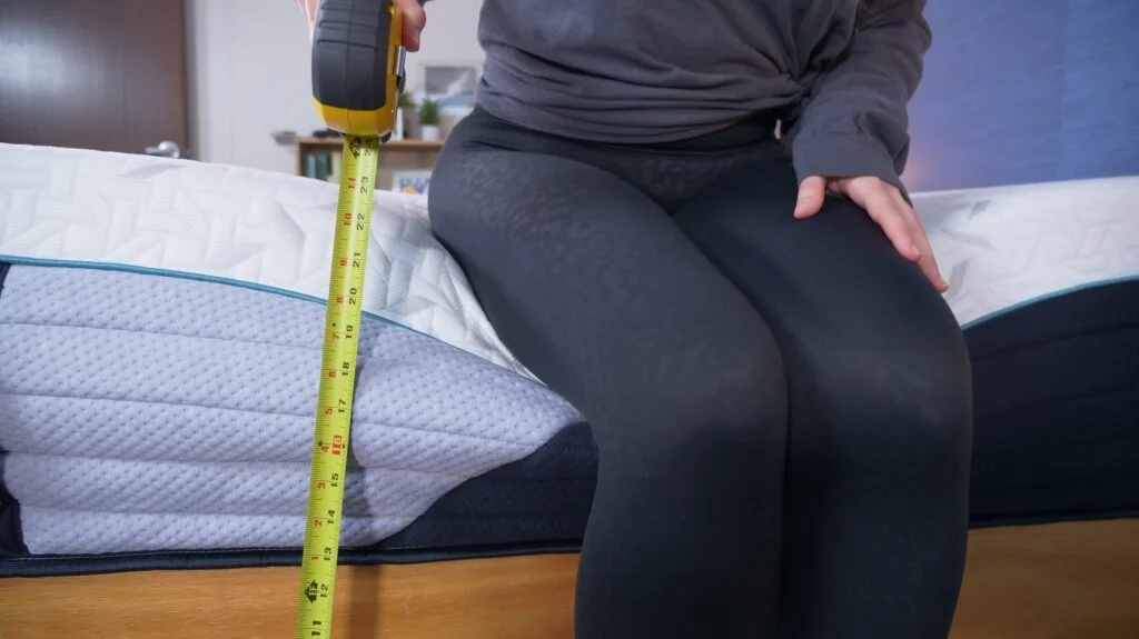 Nichole measuring the sinkage on the Nectar Premier Hybrid mattress.