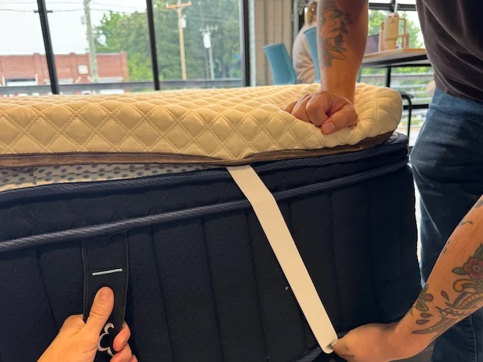 Our tester straps down a corner of the Nolah Mattress Topper