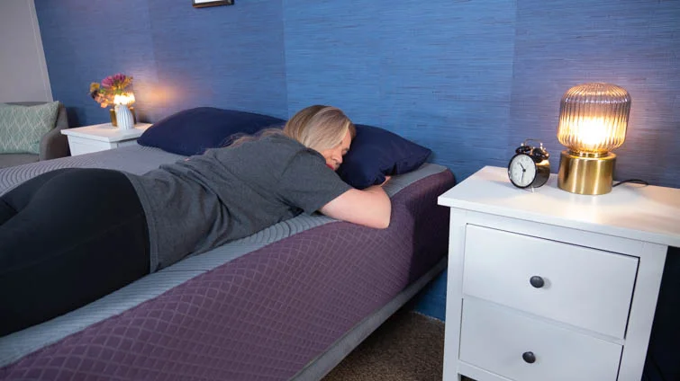 stomach sleeping on The Purple Restore Plus in the Sleepopolis studio.