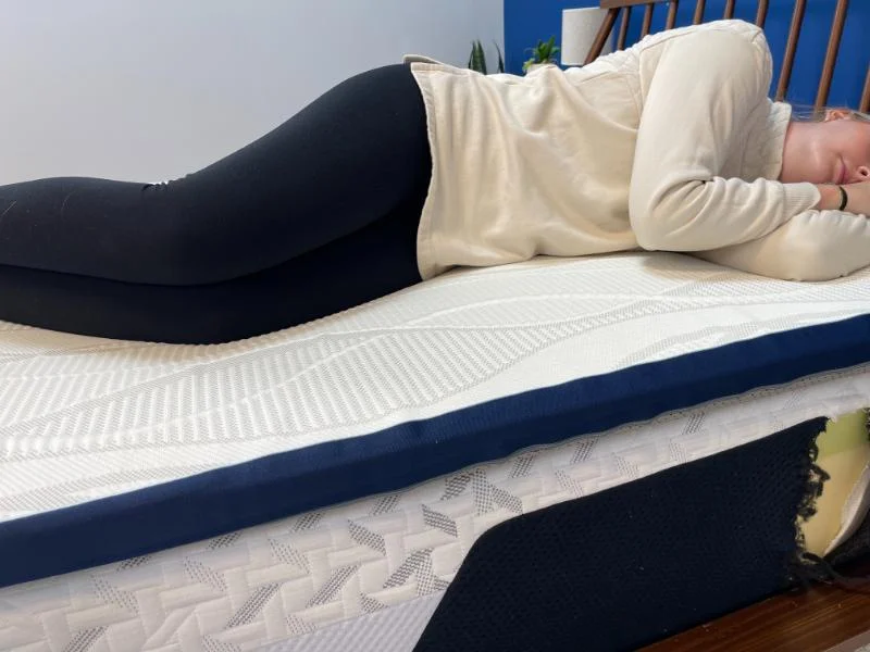 Our in-house tester tries out the Nectar Firmer Mattress Topper while sleeping on her side.