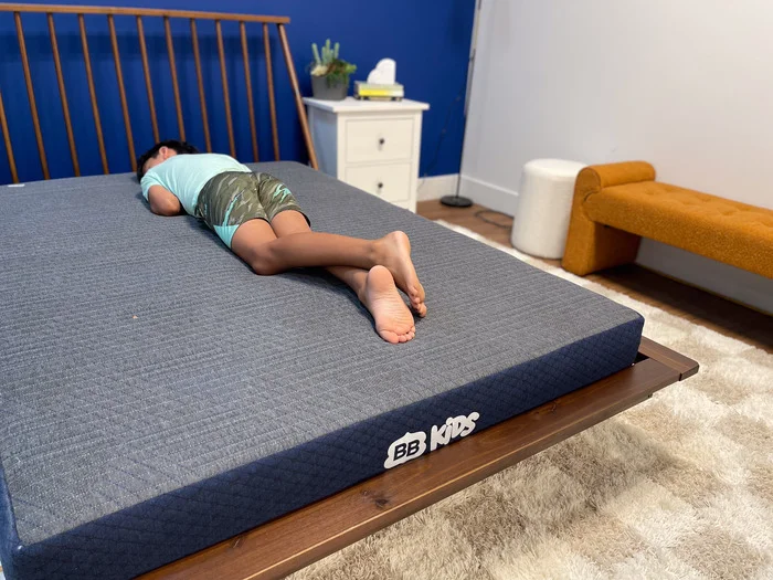 A 10-year-old boy testing out the BB Kids mattress in the stomach-sleeping position.
