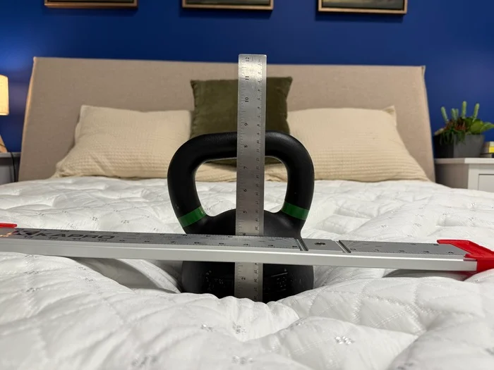 A barbell sinks into the surface of the Helix Moonlight, which is measured by a ruler