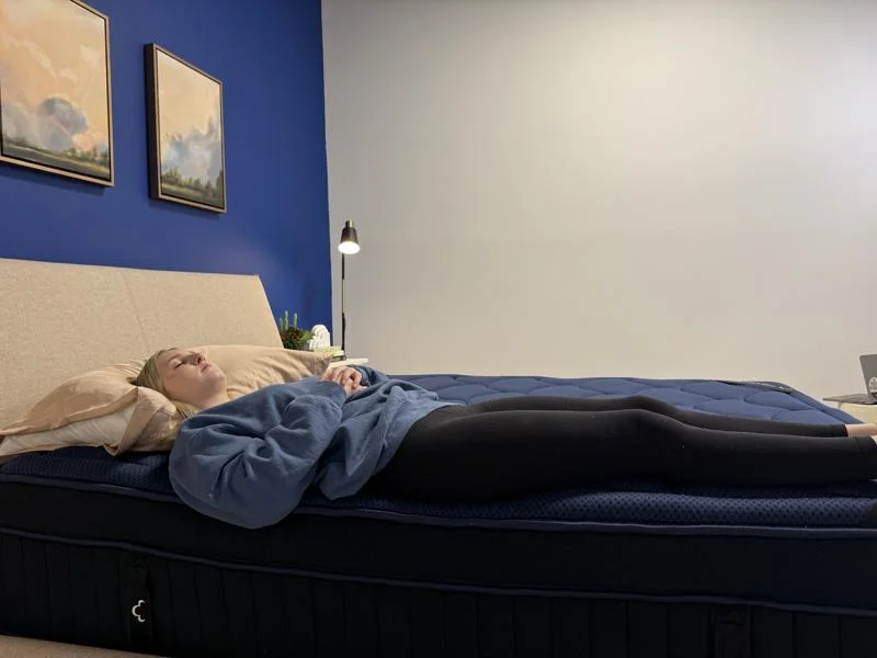 Our tester conducts a back-sleeping full body edge support test of the DreamCloud Ultra Hybrid Mattress