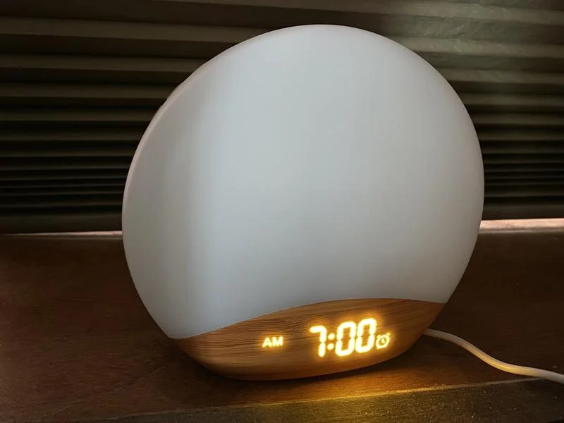 A close look at the display of a Reacher Sunrise Alarm Clock at night.