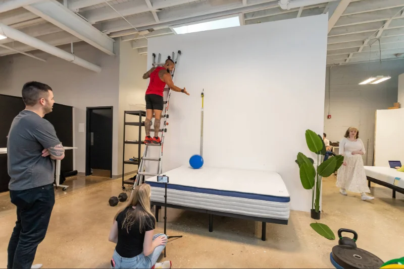 Mattress testers dropping a weighted ball onto the Helix Midnight to evaluate its responsiveness.