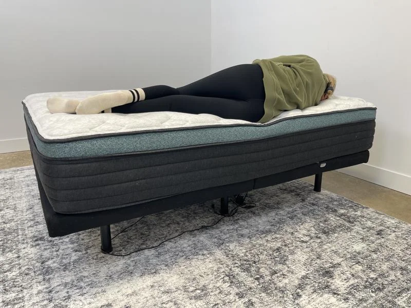 Our tester performs a side-sleeping full body edge support test of the Helix Sunset Luxe Mattress