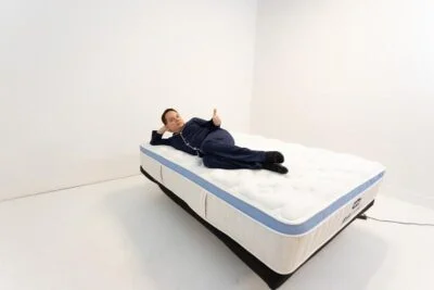 kenny gives a thumbs up while relaxing on the bear star hybrid mattress
